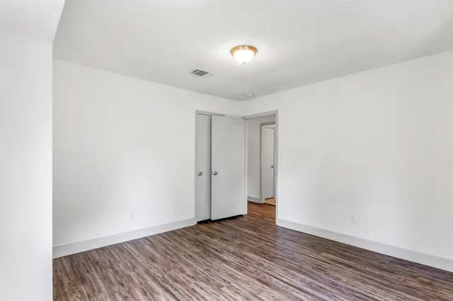 a view of an empty room with wooden floor