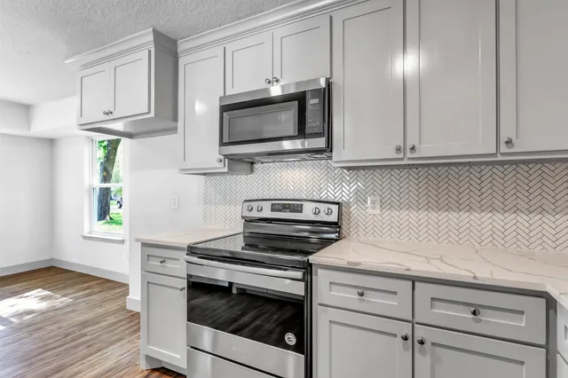 a kitchen with white cabinets and appliances