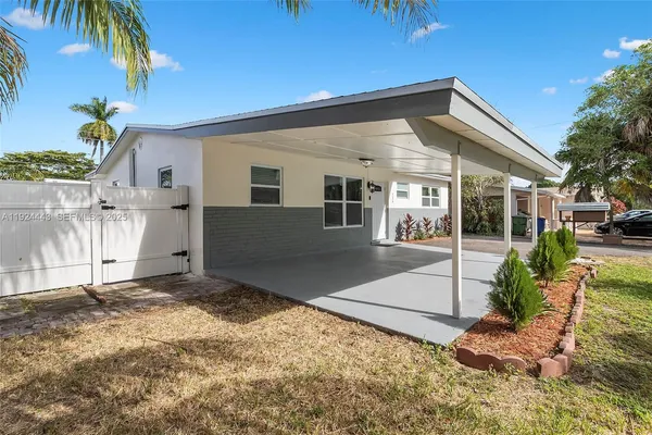 a view of a house with a yard and potted plants
