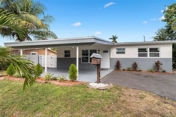 a front view of house with yard and trees in the background