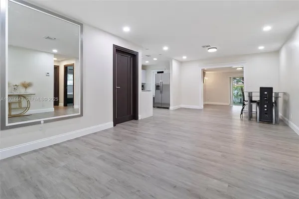 a view of a big room with wooden floor and windows