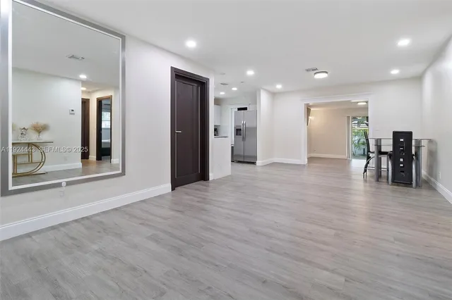 a view of a big room with wooden floor and windows