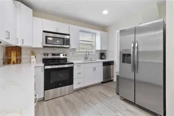a kitchen with a refrigerator stove and sink