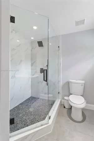 a bathroom with a toilet and a shower