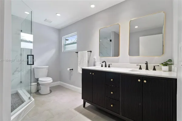 a bathroom with a double vanity sink and a toilet