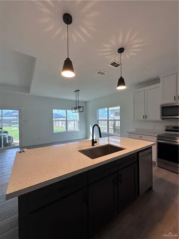 a kitchen with a sink and a stove with wooden floor