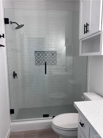 a bathroom with a sink a toilet and shower