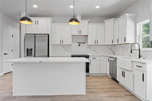 a kitchen with kitchen island a sink wooden floor and cabinets