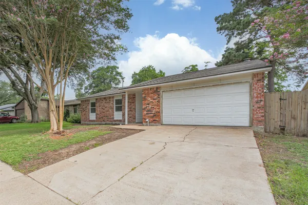 front view of a house with a yard and an trees
