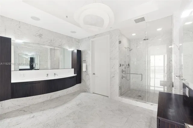 a bathroom with a bathtub a double vanity sink and mirror
