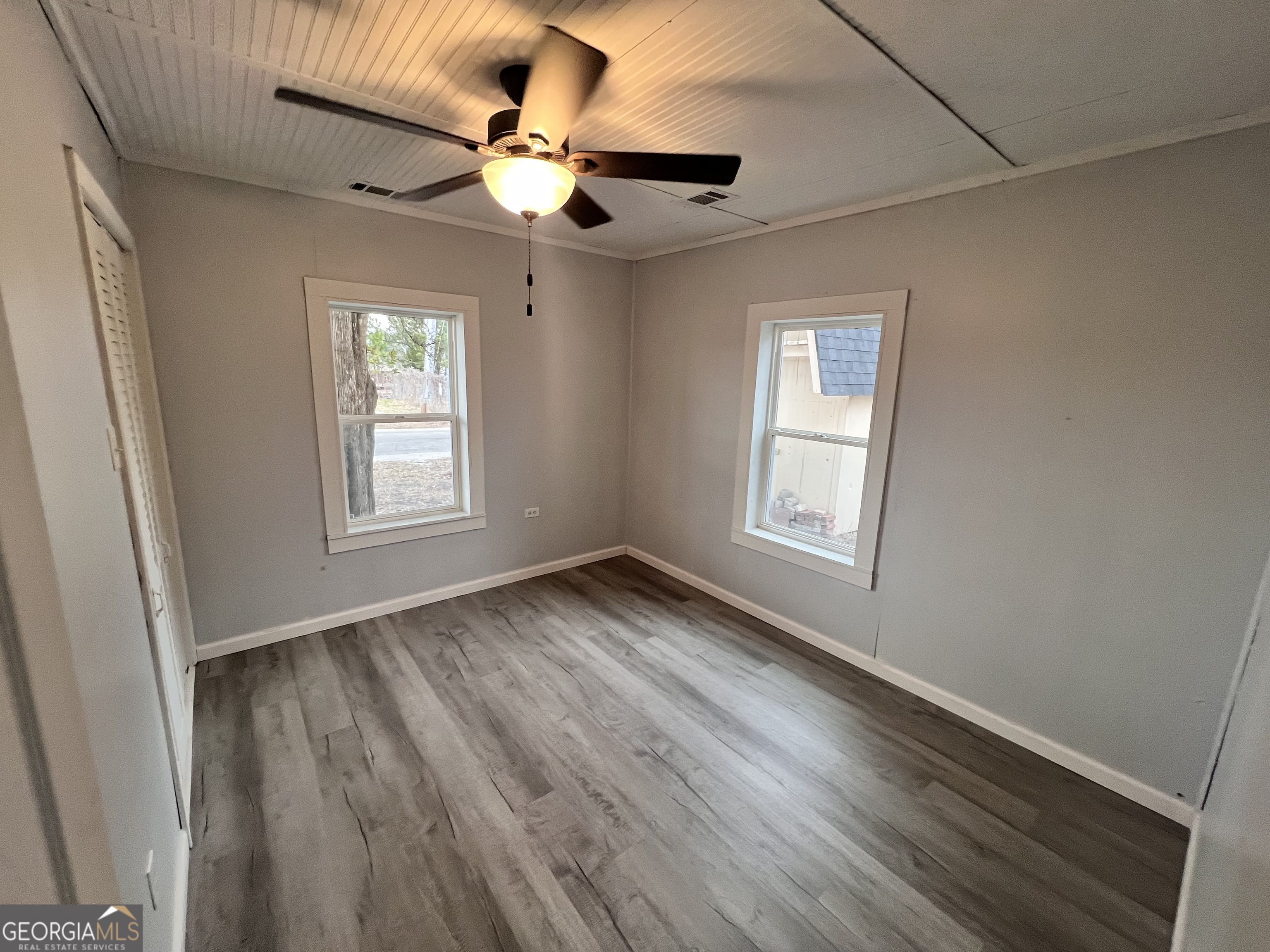 3 9th Street McRae-Helena, GA 31037 - Photo 9 of 19 an empty room with wooden floor fan and windows