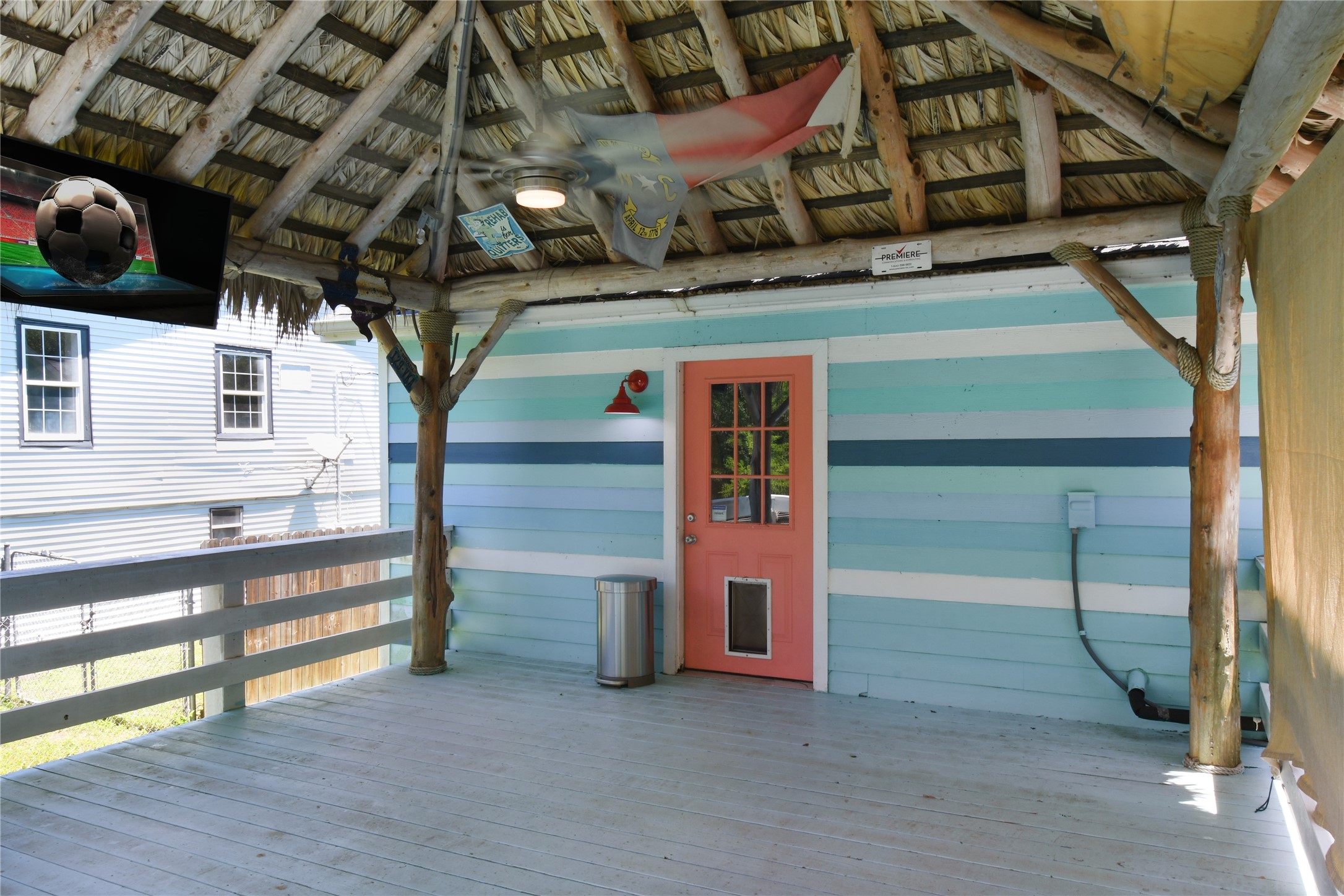 320 10th Street Dickinson, TX 77539 - Photo 5 of 21 This inviting covered deck features vibrant, beachy hues and rustic wood accents, offering a perfect blend of relaxation and entertainment space.