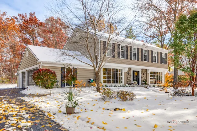 a front view of a house with a yard covered in snow