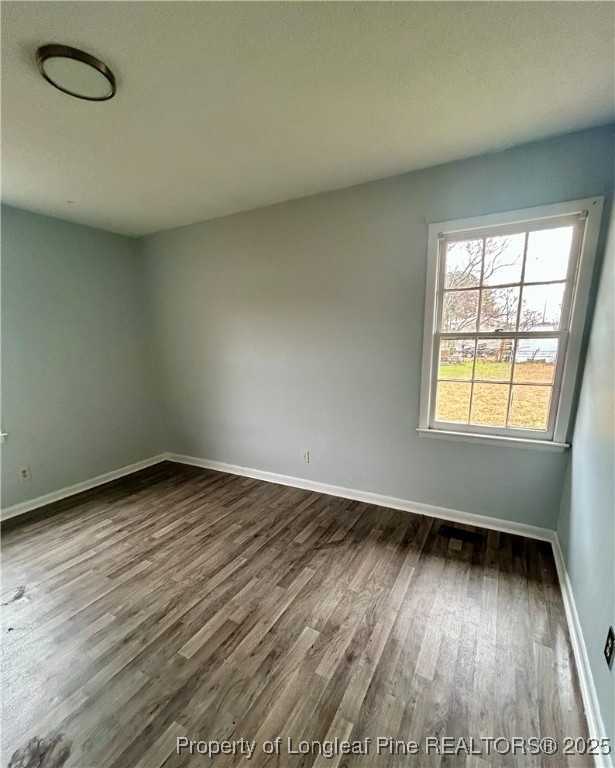 507 Oakdale Gin Road Raeford, NC 28376 - Photo 12 of 16 an empty room with wooden floor and windows
