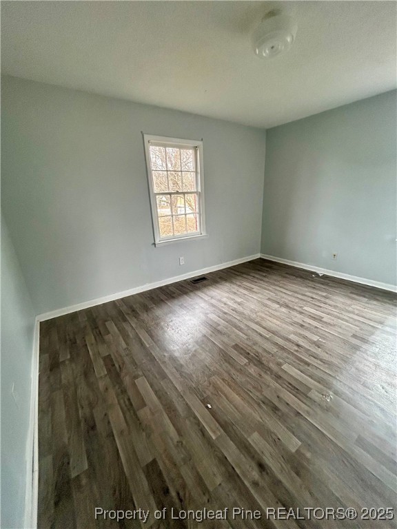 507 Oakdale Gin Road Raeford, NC 28376 - Photo 14 of 16 an empty room with wooden floor and windows
