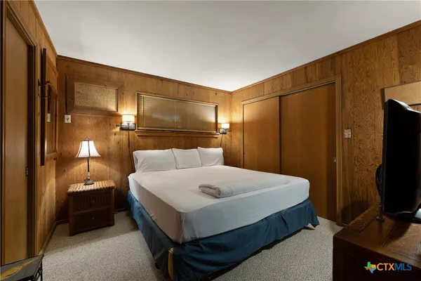 a bedroom with a bed and a flat screen tv