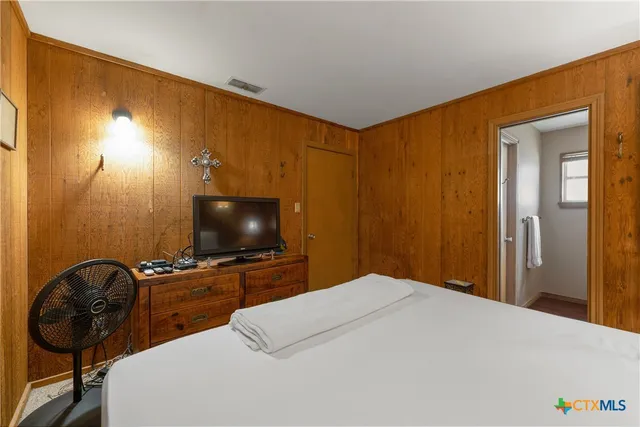 a bedroom with a bed and a flat screen tv