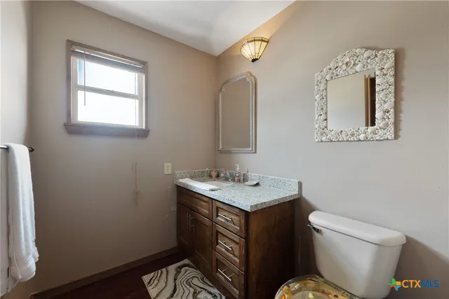 a bathroom with a toilet sink and mirror