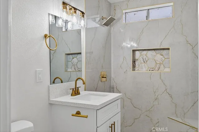 a bathroom with a sink vanity and a shower