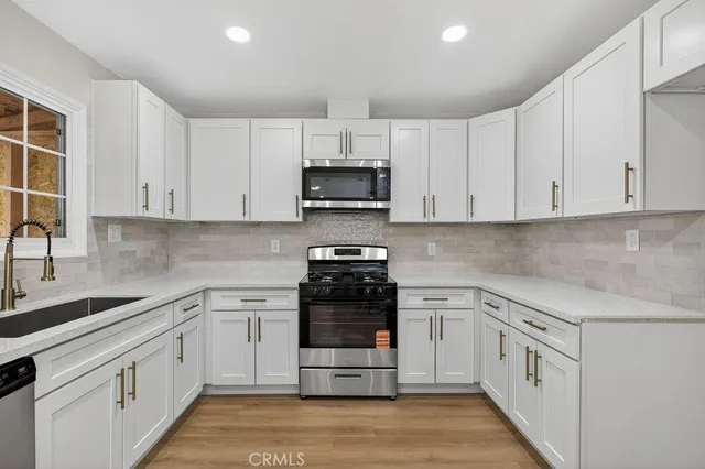 a kitchen with white cabinets and appliances
