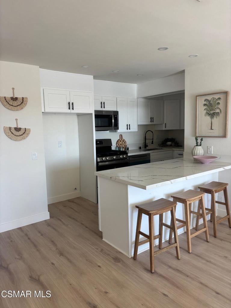 916 Lighthouse Way Port Hueneme, CA 93041 - Photo 5 of 26 a kitchen with a table chairs refrigerator and cabinets
