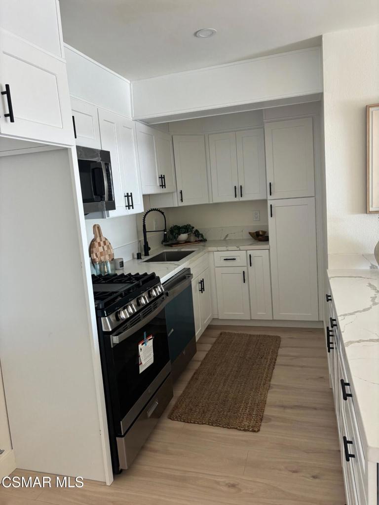 916 Lighthouse Way Port Hueneme, CA 93041 - Photo 6 of 26 a kitchen with a stove and a microwave