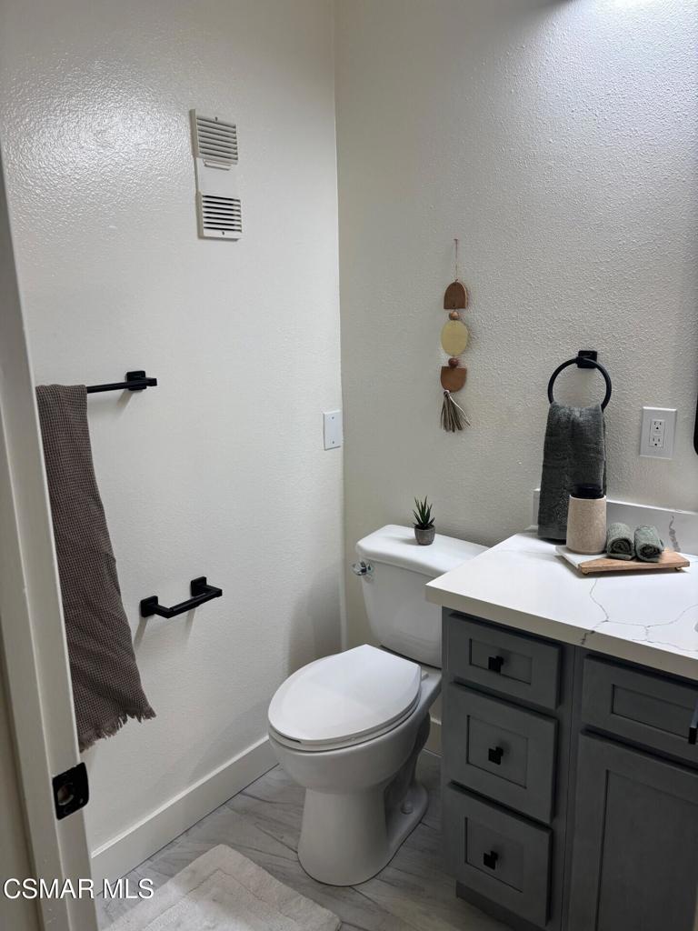 916 Lighthouse Way Port Hueneme, CA 93041 - Photo 8 of 26 a bathroom with a granite countertop toilet a sink and a mirror
