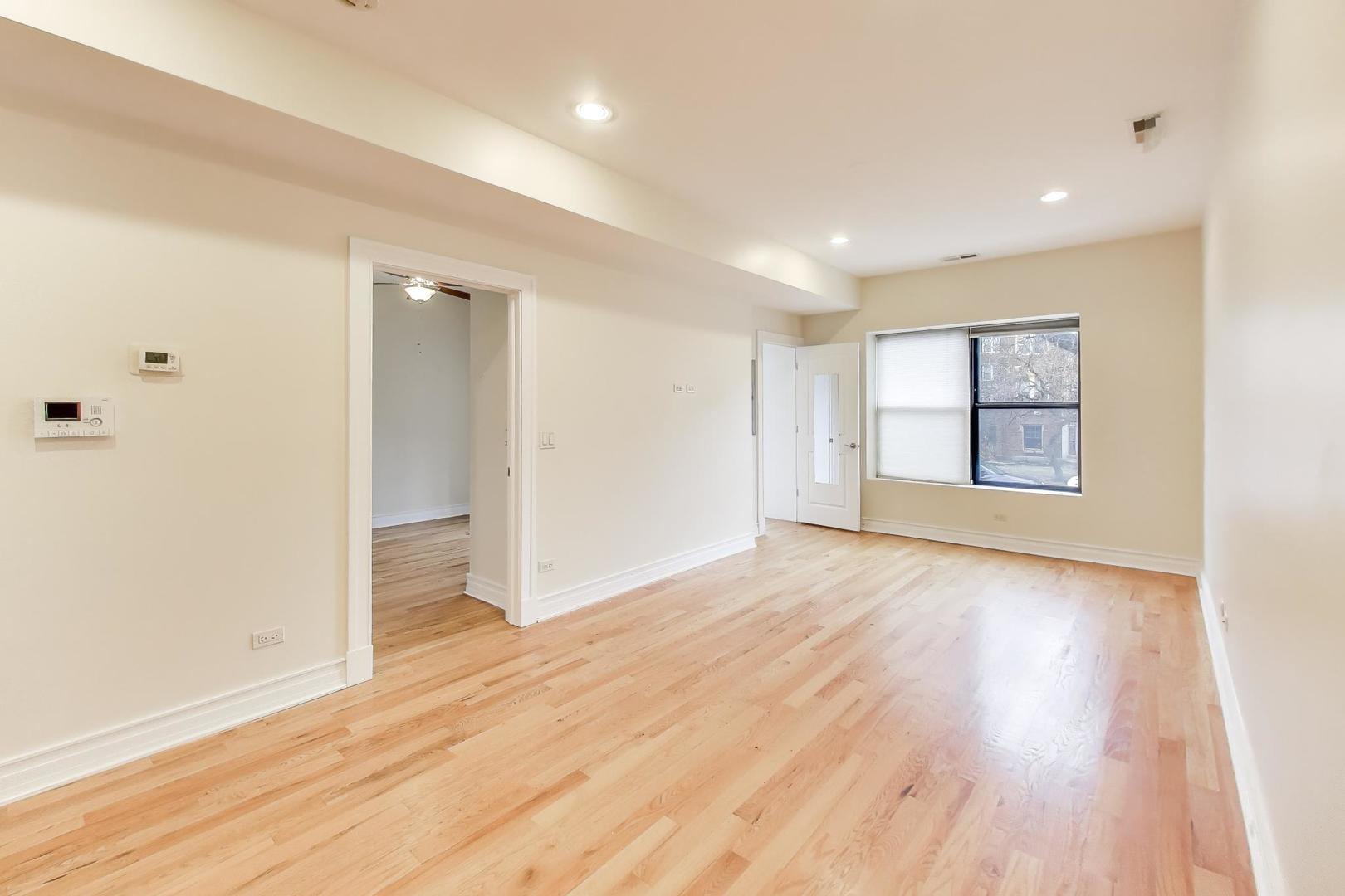 1640 West Fargo Avenue, Unit 101 Chicago, IL 60626 - Photo 5 of 22 wooden floor in an empty room with a window