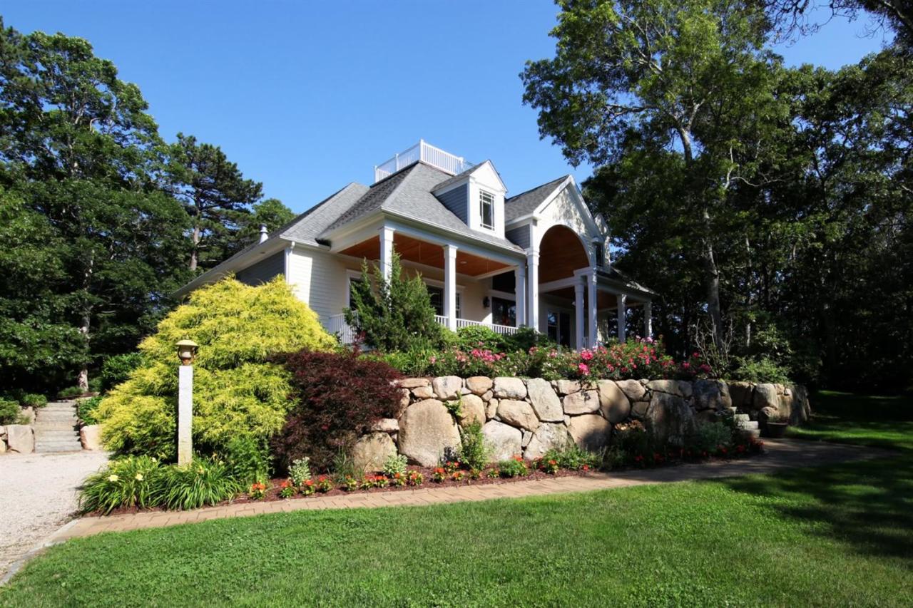 11 Harbor Ridge Road Mashpee, MA 02649 - Photo 3 of 33 a front view of a house with a garden and plants