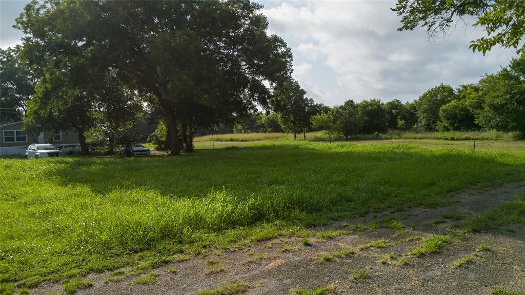 103 Atlantic Street Cleburne, TX 76031 - Photo 2 of 5 Expansive green space featuring mature trees and a gravel drive