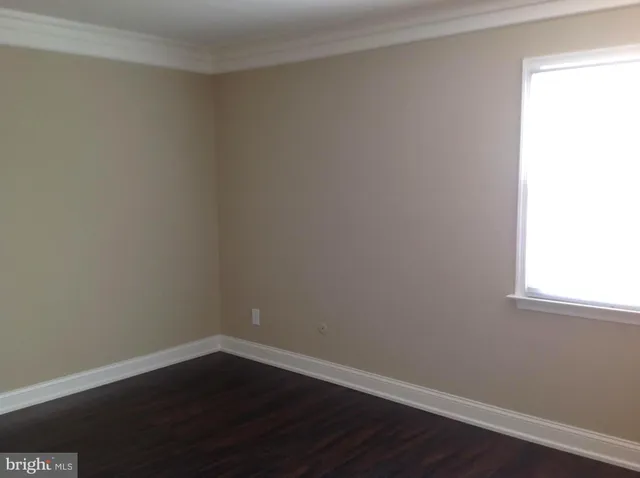 a view of a small space with wooden floor and a window