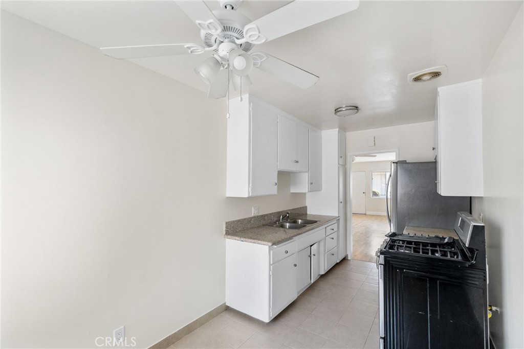 7137 Ramsgate Avenue Los Angeles, CA 90045 - Photo 6 of 14 a kitchen with granite countertop a stove and a refrigerator