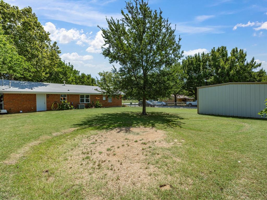 714 Decatur Street Bowie, TX 76230 - Photo 2 of 16 Large Back Yard, Fenced, with mature Trees and a 20 x 20 Outbuilding