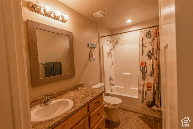 660 East 400 North Spring City, UT 84662 - Photo 5 of 16 Bathroom with a textured ceiling, wood finished floors, toilet, vanity, and shower / bath combination with curtain