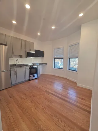 a large kitchen with stainless steel appliances granite countertop a stove a sink and a refrigerator