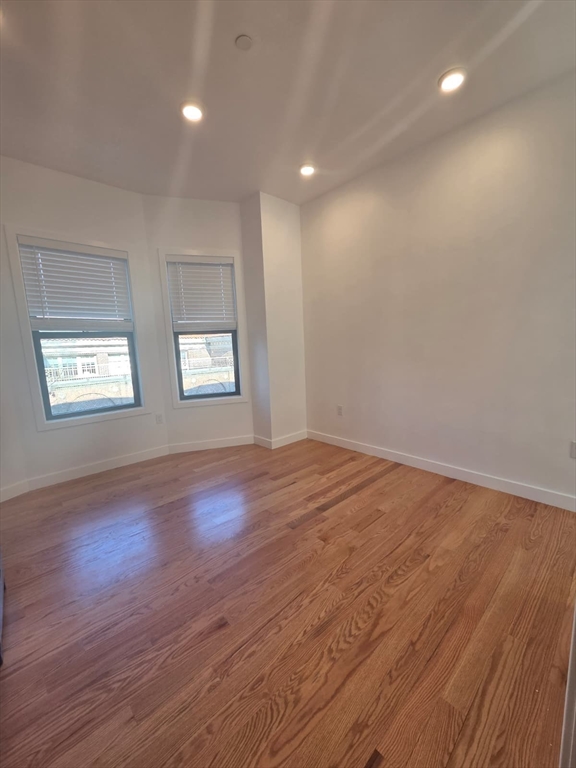 165 Hawthorne Street, Unit 303 Chelsea, MA 02150 - Photo 3 of 14 an empty room with wooden floor and windows