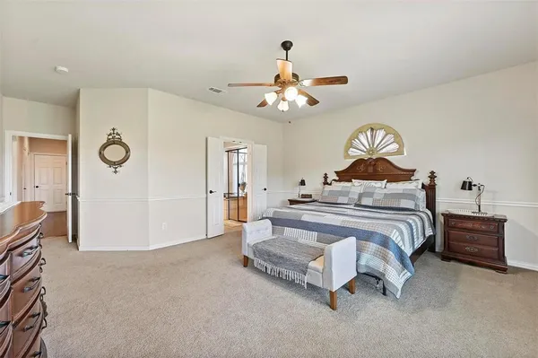 a spacious bedroom with a bed and a chandelier