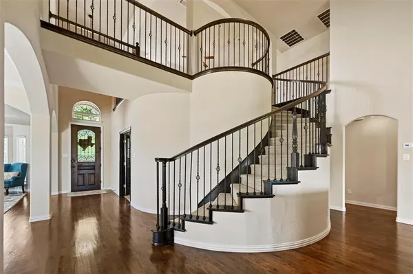 a view of staircase with railing and a chandelier