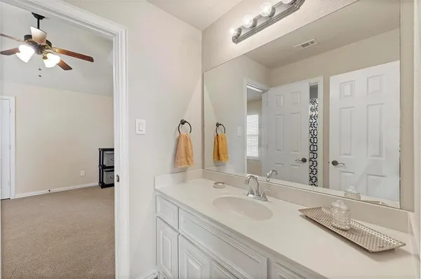 a bathroom with a granite countertop double vanity sink and a mirror