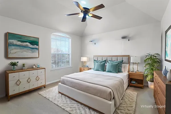 a bedroom with a bed and a chandelier fan