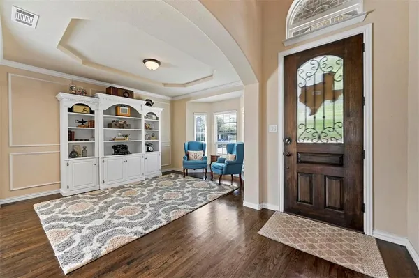 a view of a hallway with wooden floor and windows
