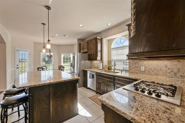 a kitchen with stainless steel appliances granite countertop a sink stove and refrigerator