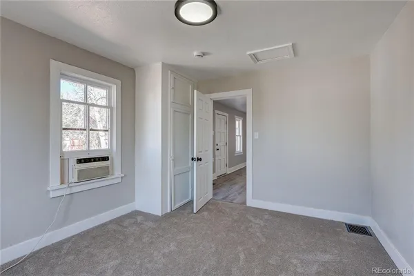 an empty room with windows and closet