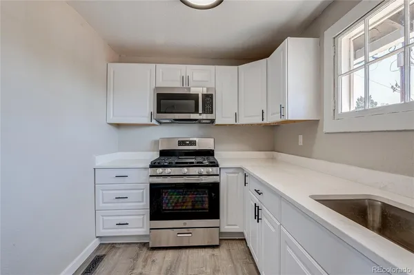 a kitchen with cabinets stainless steel appliances a sink and a stove