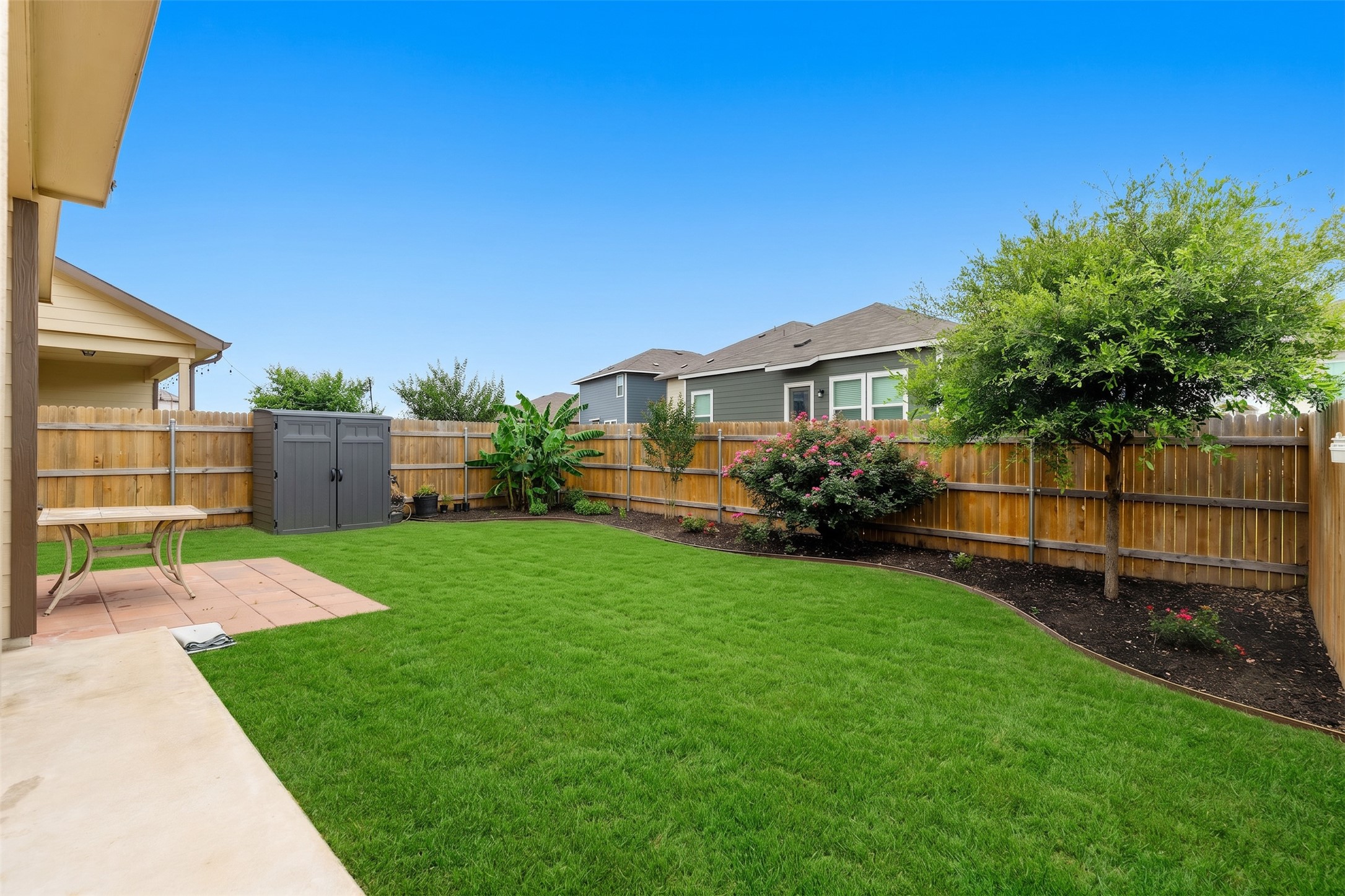 425 Perfect World Loop Jarrell, TX 76537 - Photo 27 of 29 Expansive backyard featuring a large grass lawn, perimeter wood fencing, and established landscaping