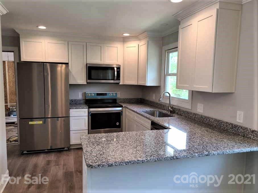 1 Old Farm Road Salisbury, NC 28147 - Photo 3 of 4 a kitchen with granite countertop a refrigerator a sink a stove a microwave a counter top and cabinetry
