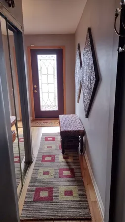 a view of a hallway view with wooden floor and a rug