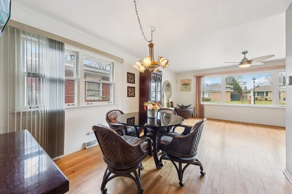 a dining room with furniture a chandelier and wooden floor