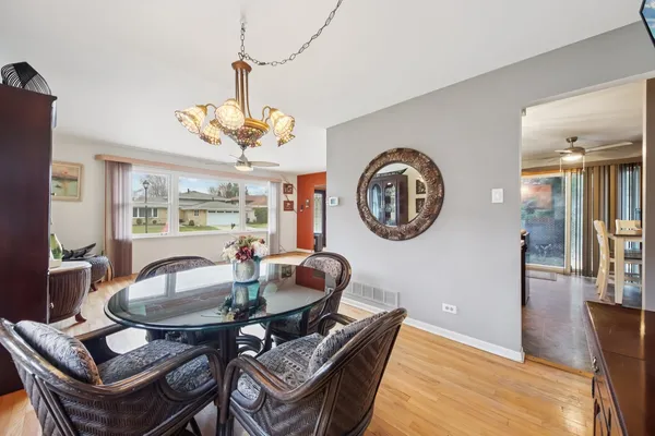 a dining room with furniture a rug and a mirror