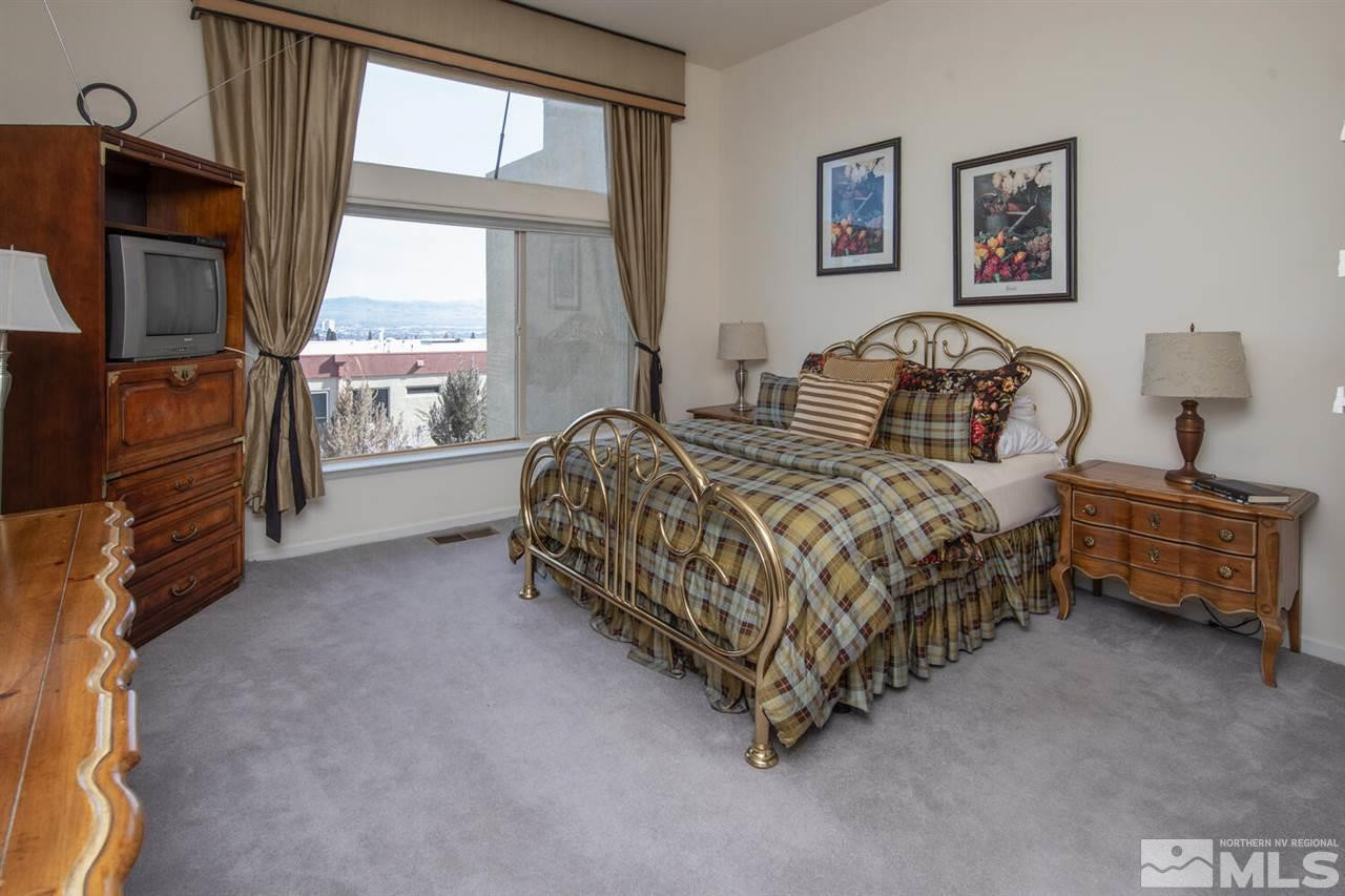 3345 Skyline Boulevard Reno, NV 89509 - Photo 11 of 38 a bedroom with a bed a couch and a flat tv screen on dresser